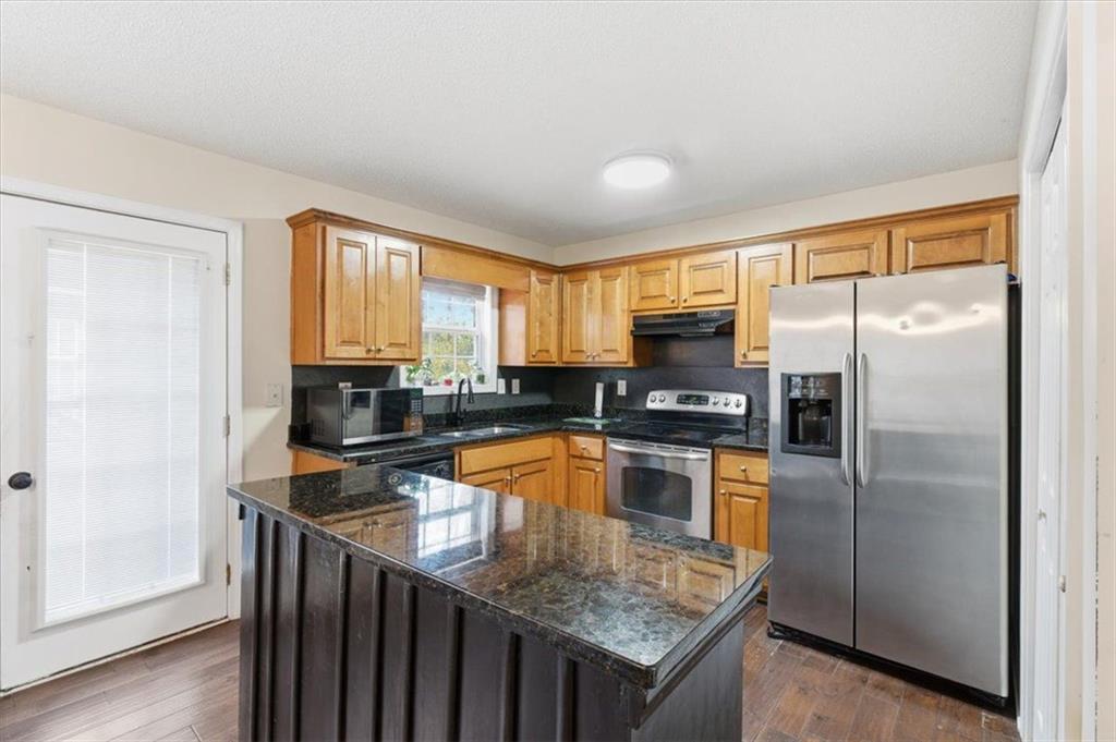 127 Prince Albert Court Southwest Calhoun, GA 30701 - Photo 12 of 50 a kitchen with granite countertop a refrigerator a sink a stove and island