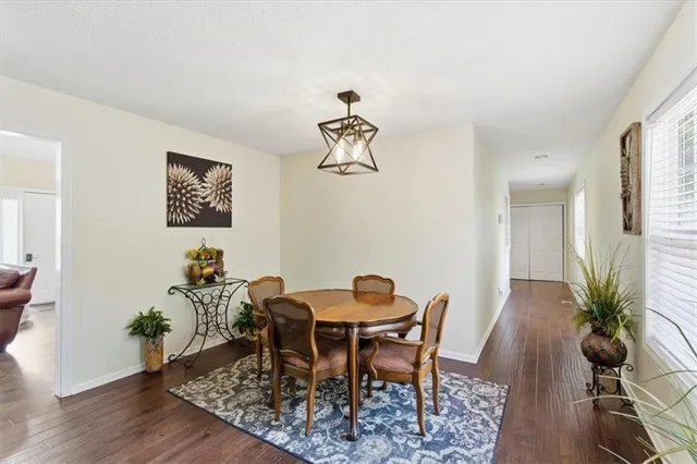 a dining room with furniture potted plants and wooden floor