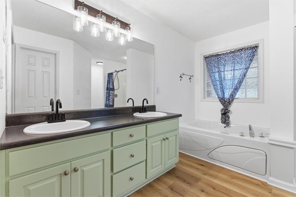 127 Prince Albert Court Southwest Calhoun, GA 30701 - Photo 25 of 50 a bathroom with a granite countertop sink a mirror and a bathtub