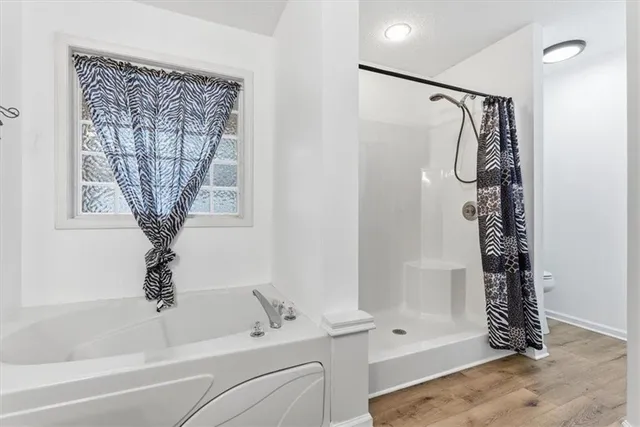 a bathroom with a shower a toilet and a window