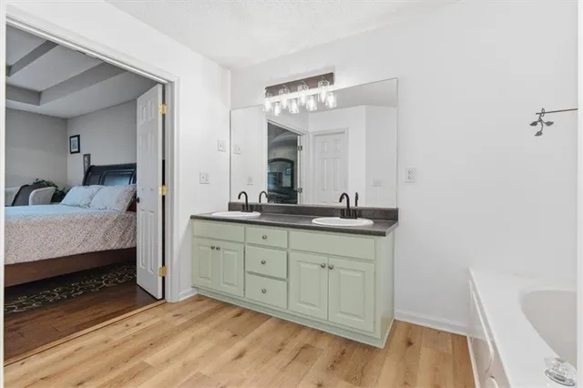a spacious bathroom with a granite countertop sink and a mirror