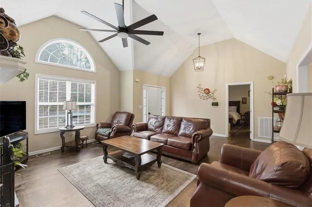 a living room with furniture a chandelier and a flat screen tv