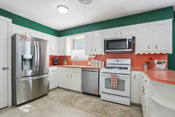 a kitchen with stainless steel appliances and white cabinets