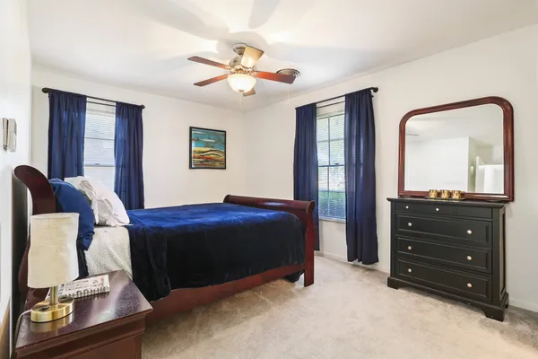 a bedroom with a bed and a mirror on dresser
