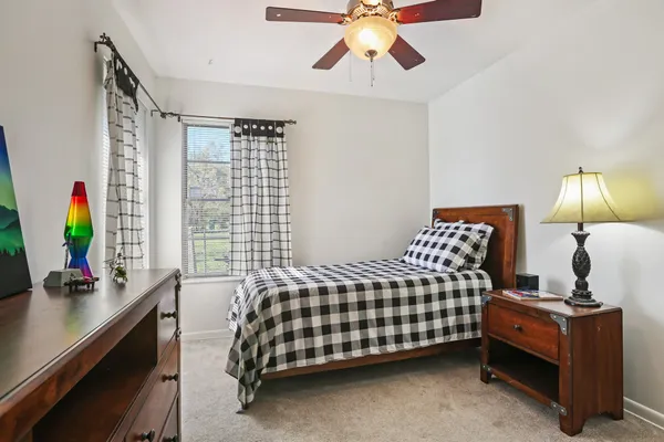 a bedroom with a bed work place and a lamp