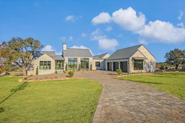 a front view of house with yard and trees in the background