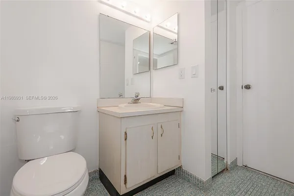 a bathroom with a toilet a sink and mirror