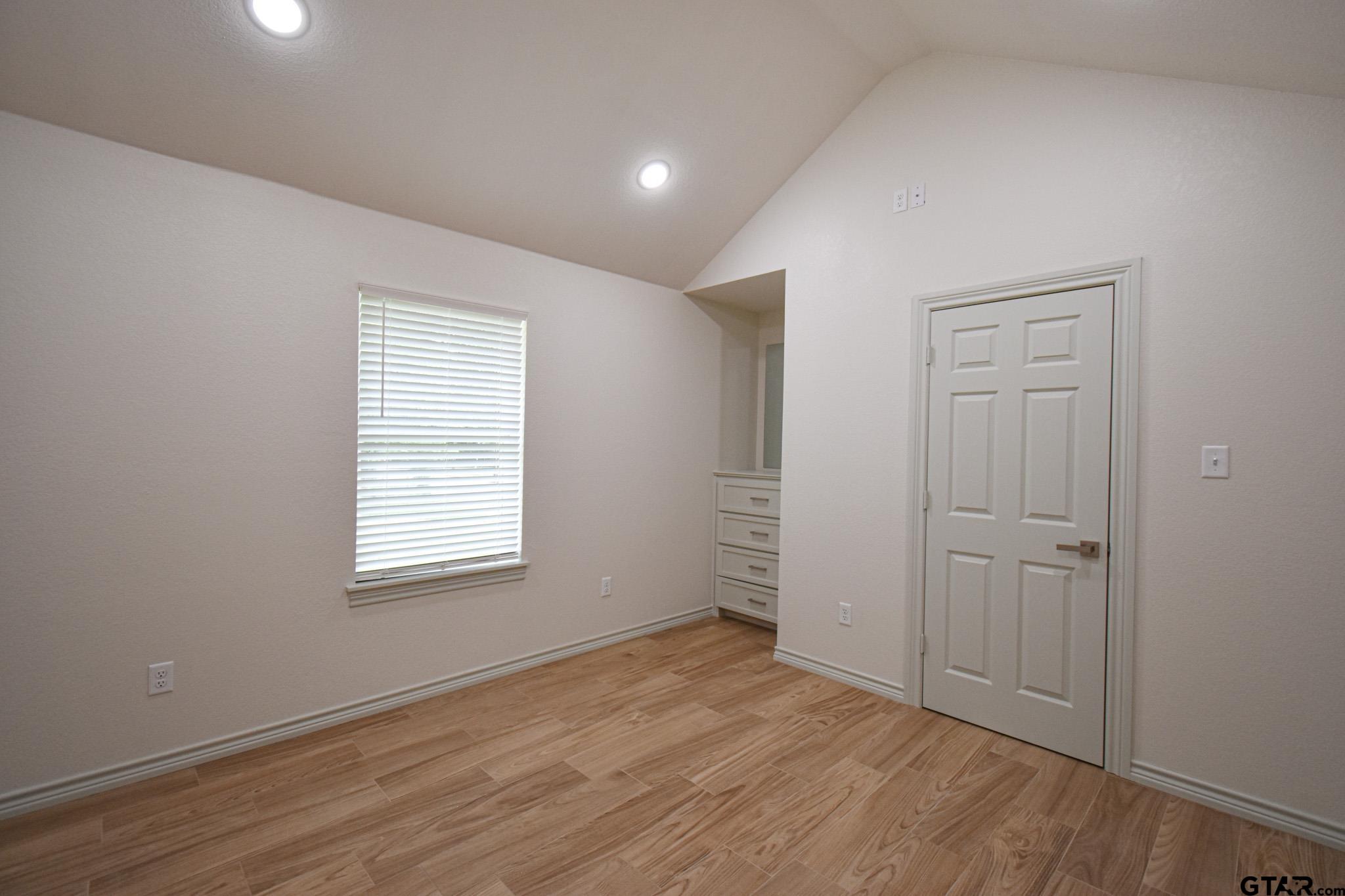 1417 East Earle Street Tyler, TX 75702 - Photo 18 of 31 an empty room with wooden floor and windows
