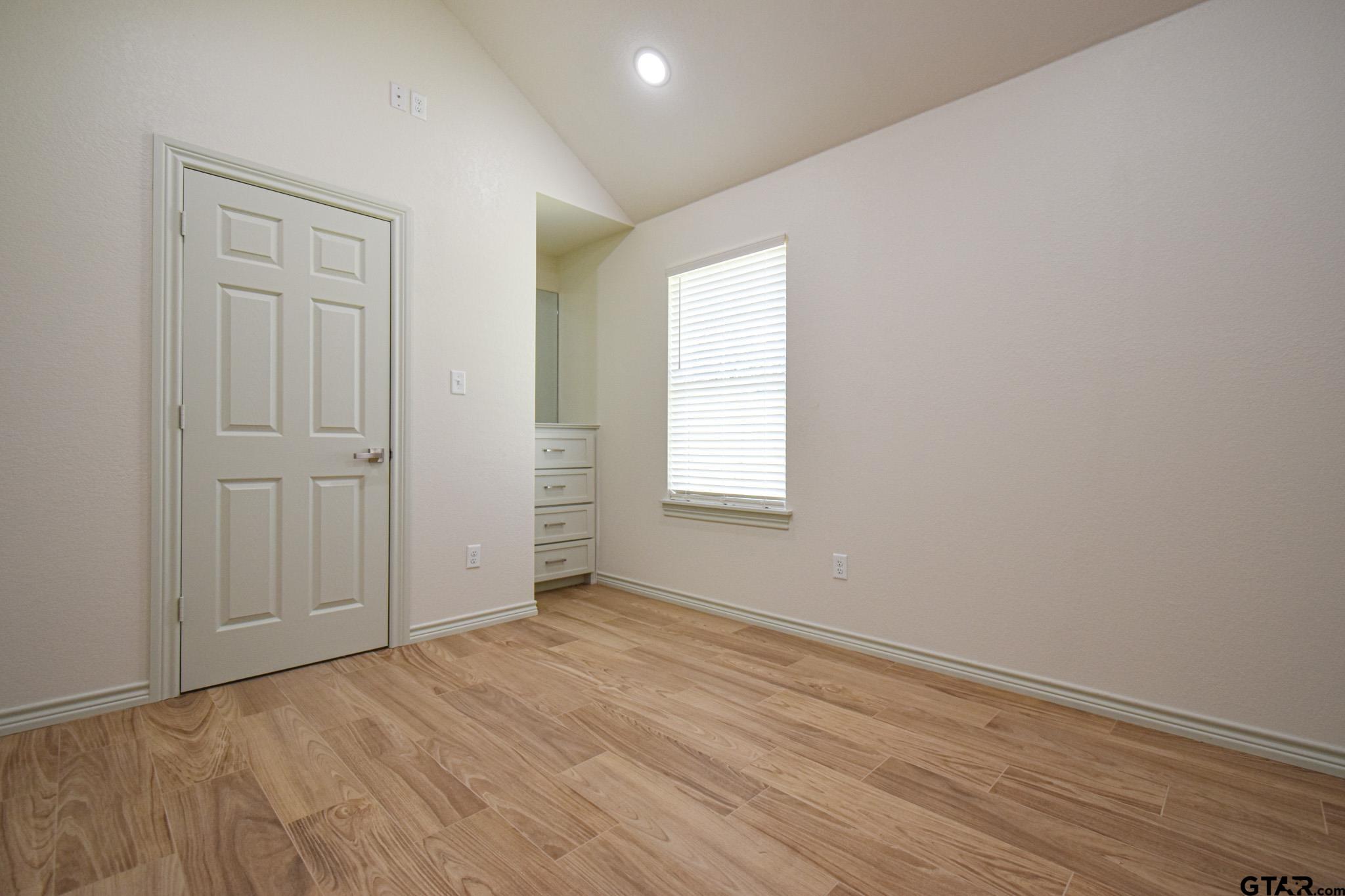 1417 East Earle Street Tyler, TX 75702 - Photo 24 of 31 an empty room with wooden floor and windows
