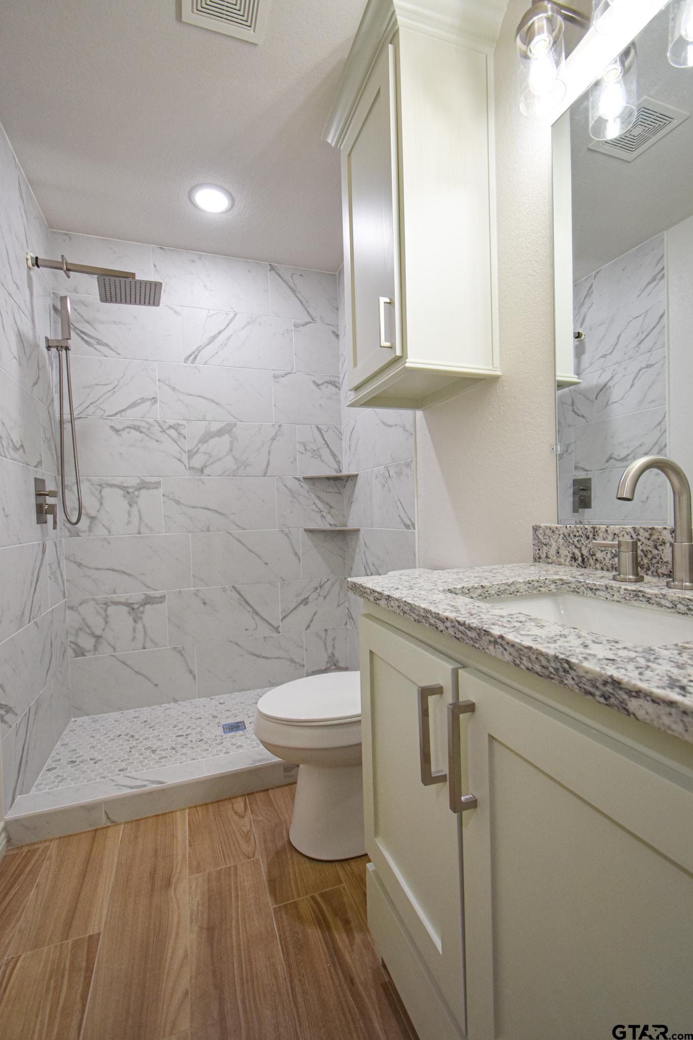 1417 East Earle Street Tyler, TX 75702 - Photo 28 of 31 a bathroom with a granite countertop sink toilet and shower