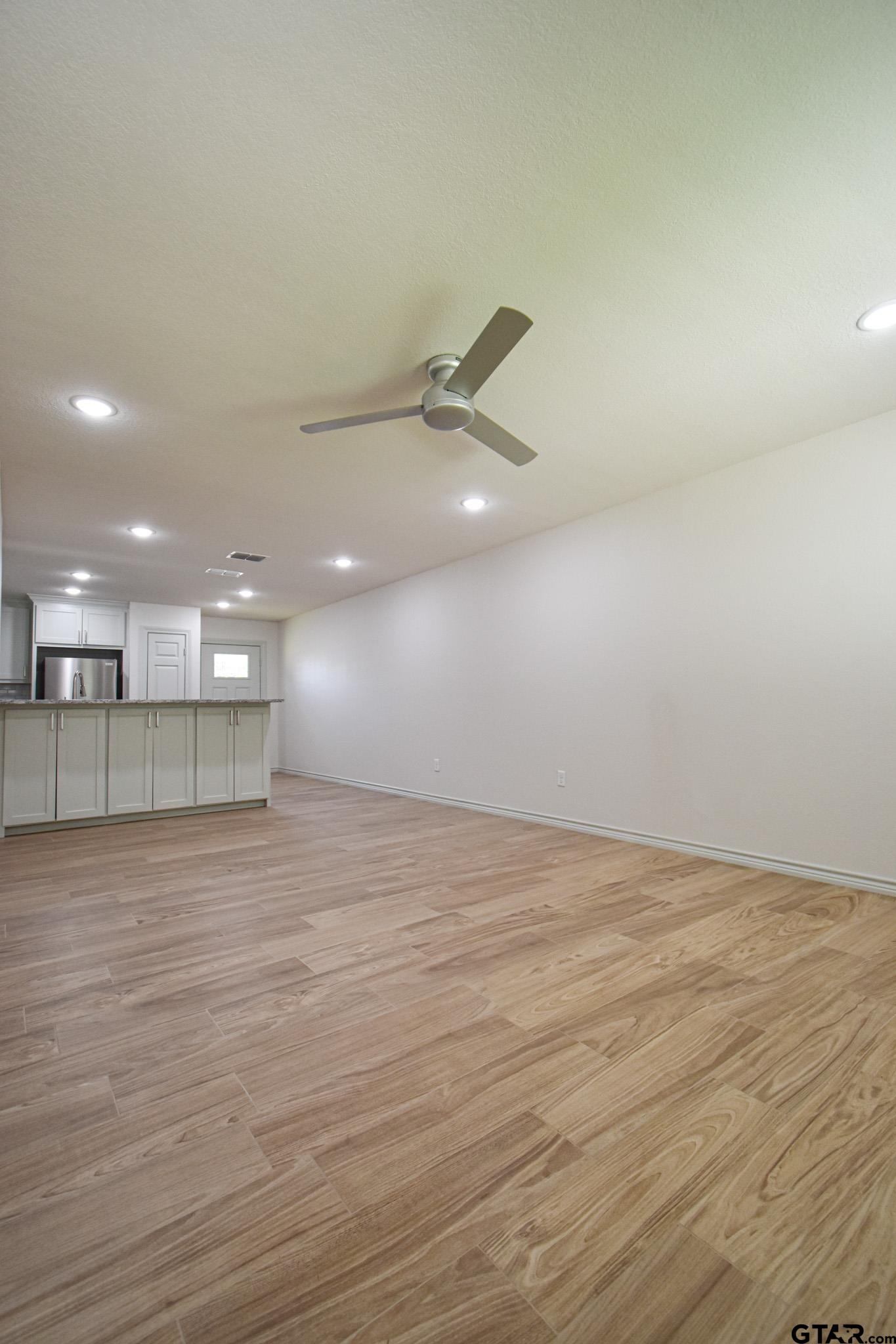 1417 East Earle Street Tyler, TX 75702 - Photo 6 of 31 an empty room with wooden floor and windows