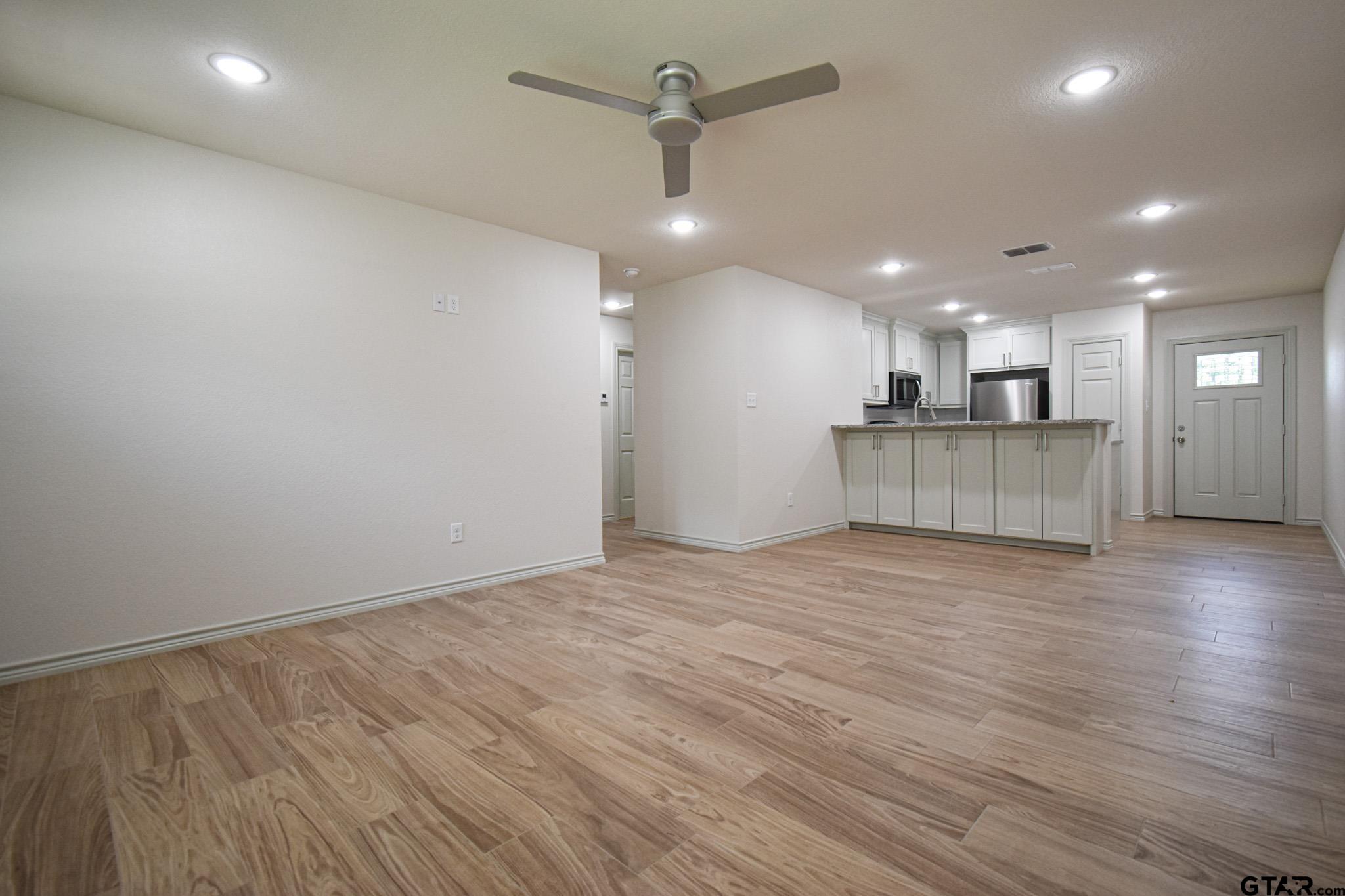 1417 East Earle Street Tyler, TX 75702 - Photo 7 of 31 a view of a kitchen with a sink and a refrigerator
