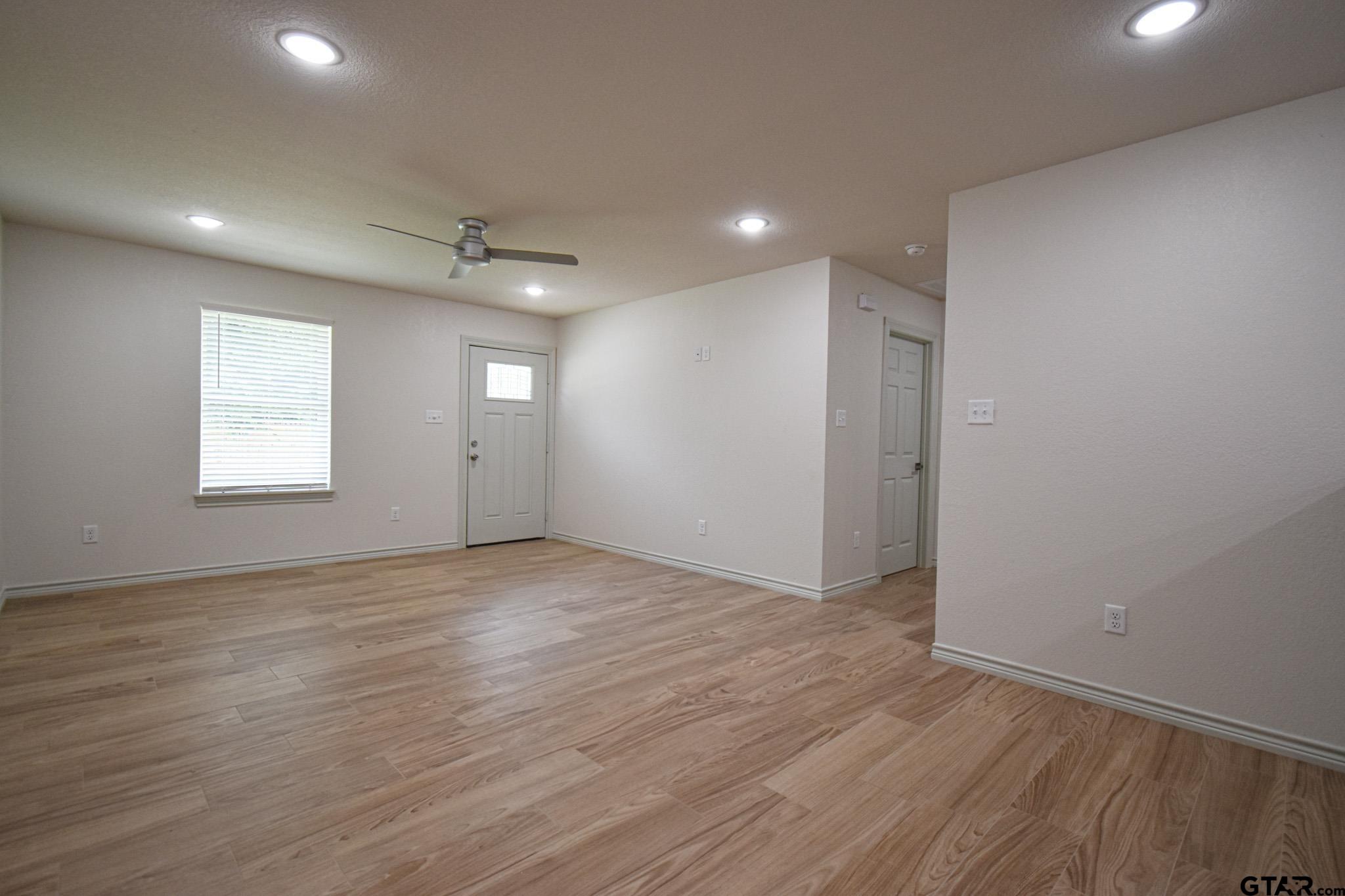 1417 East Earle Street Tyler, TX 75702 - Photo 8 of 31 an empty room with wooden floor and windows