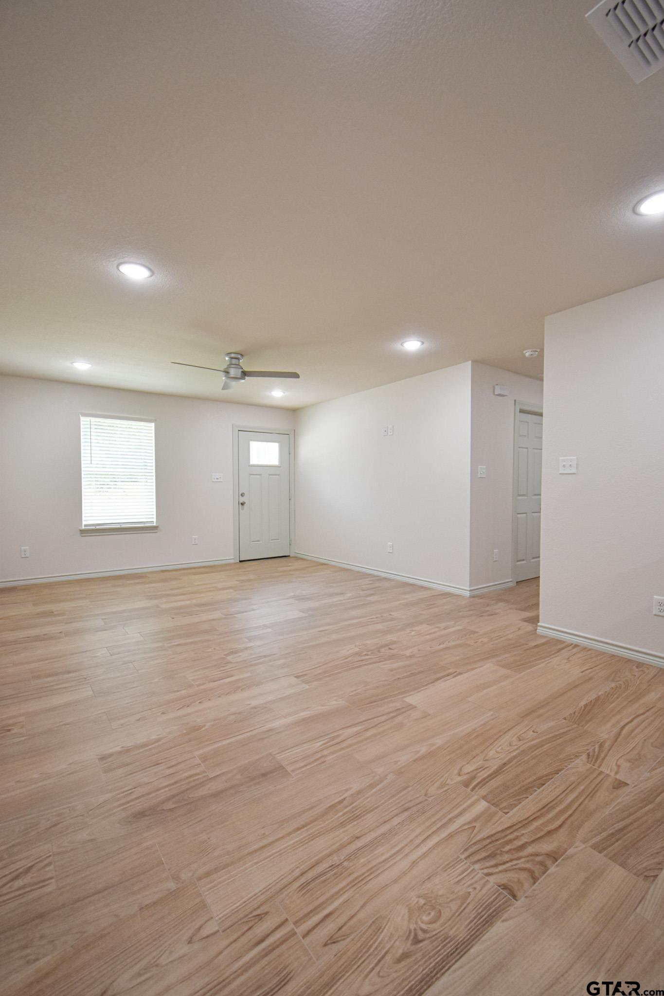 1417 East Earle Street Tyler, TX 75702 - Photo 9 of 31 a view of an empty room with wooden floor and a window