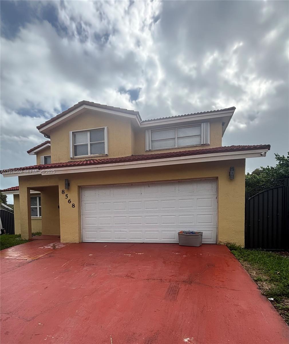 8568 Southwest 211th Terrace, Unit 8576 Cutler Bay, FL 33189 - Photo 1 of 12 a front view of a house with a yard