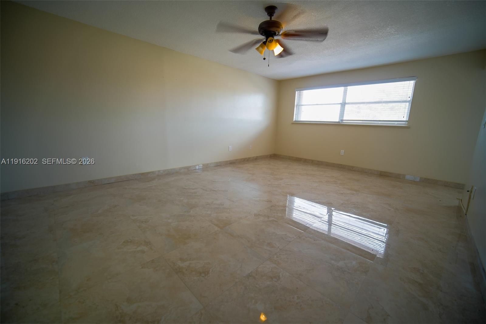 8568 Southwest 211th Terrace, Unit 8576 Cutler Bay, FL 33189 - Photo 12 of 26 an empty room with windows and ceiling fan