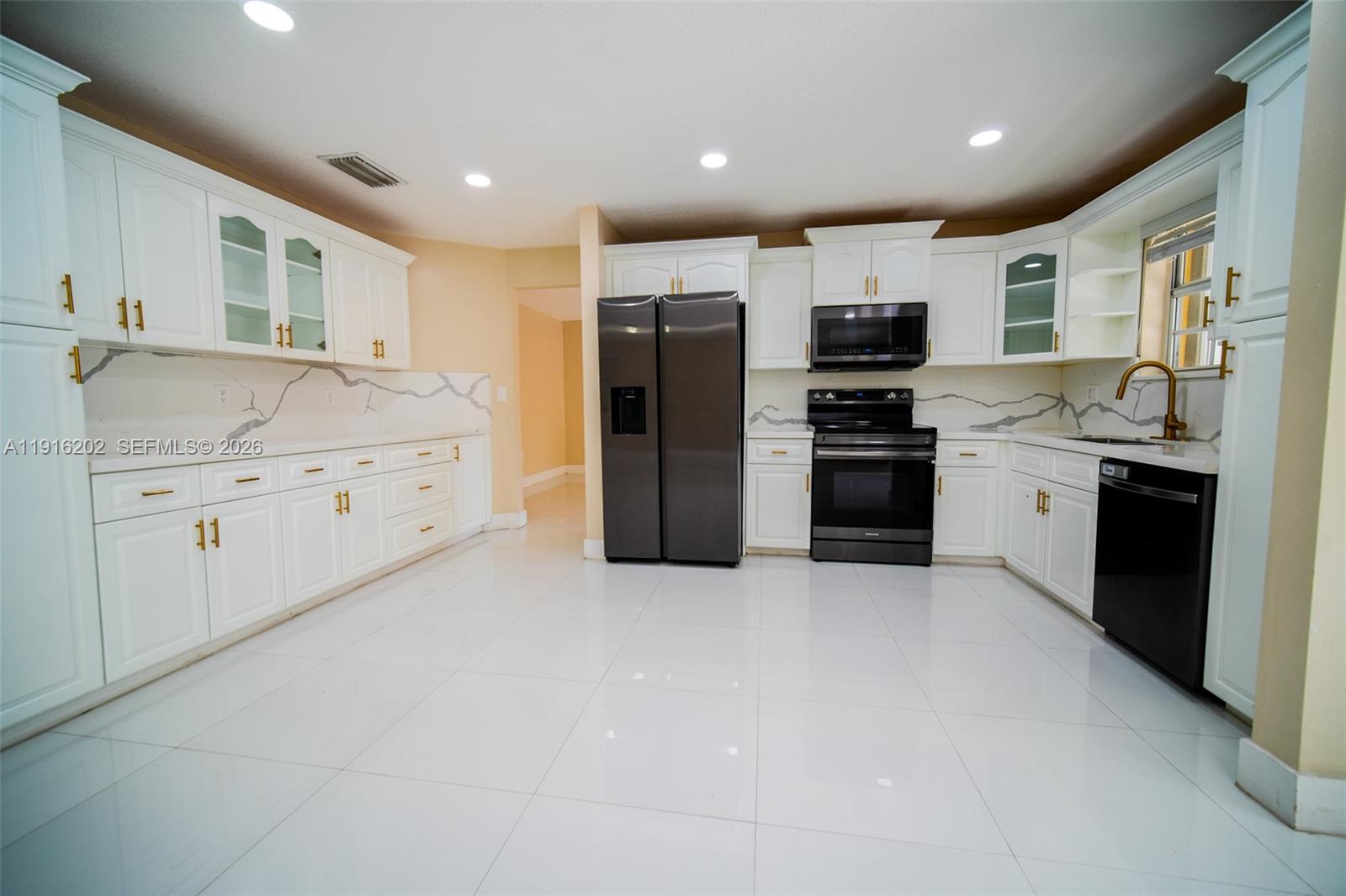 8568 Southwest 211th Terrace, Unit 8576 Cutler Bay, FL 33189 - Photo 2 of 26 a kitchen with stainless steel appliances granite countertop a refrigerator and a stove top oven