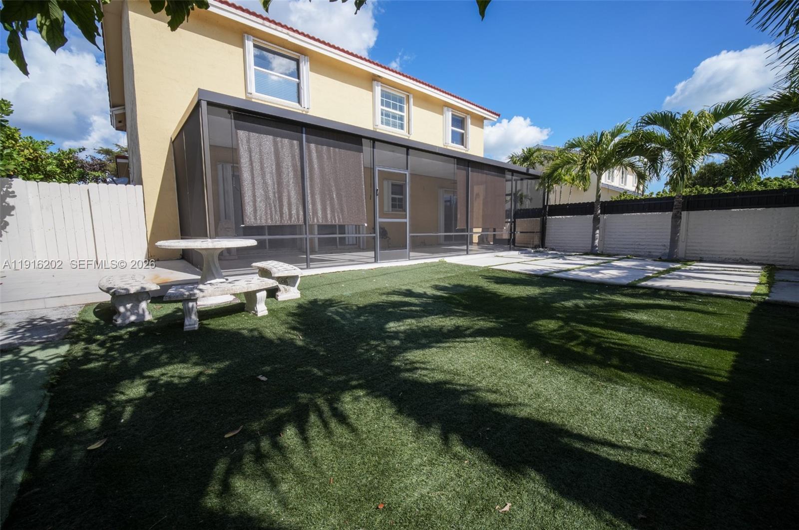 8568 Southwest 211th Terrace, Unit 8576 Cutler Bay, FL 33189 - Photo 21 of 26 a backyard of a house with table and chairs