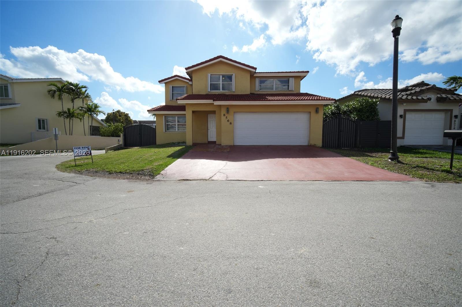 8568 Southwest 211th Terrace, Unit 8576 Cutler Bay, FL 33189 - Photo 24 of 26 a front view of a house with a yard and garage