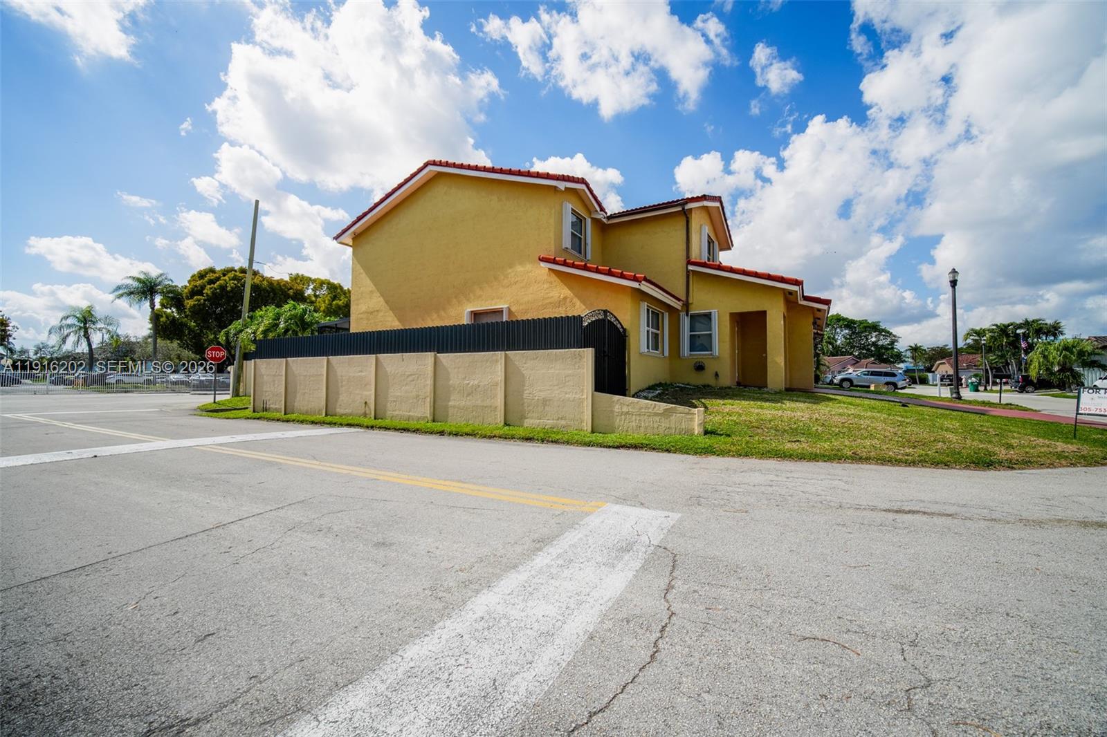8568 Southwest 211th Terrace, Unit 8576 Cutler Bay, FL 33189 - Photo 25 of 26 a front view of a house with a garden and yard