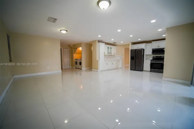 a view of an empty room with a refrigerator
