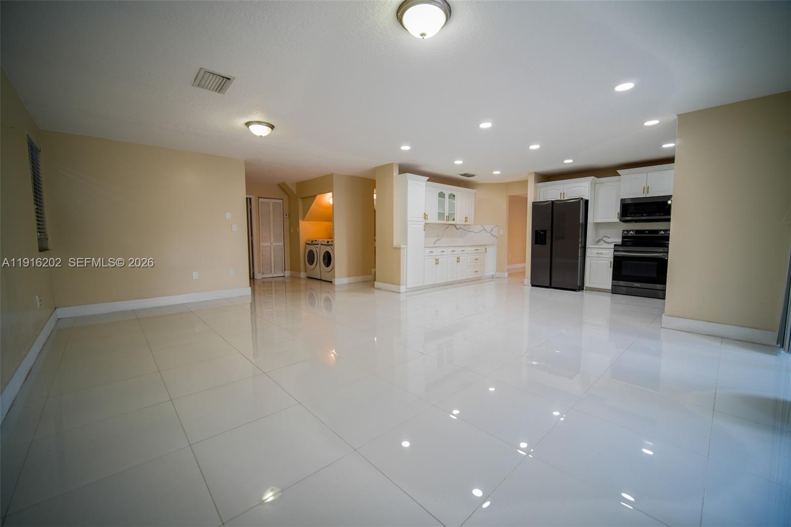 8568 Southwest 211th Terrace, Unit 8576 Cutler Bay, FL 33189 - Photo 3 of 26 a view of an empty room with a refrigerator