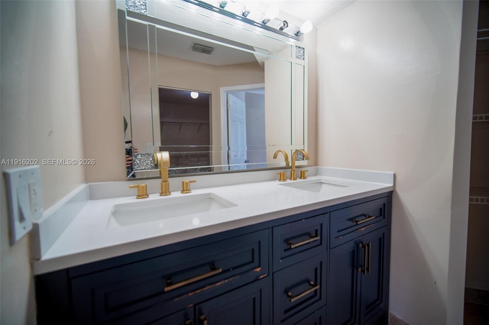8568 Southwest 211th Terrace, Unit 8576 Cutler Bay, FL 33189 - Photo 5 of 26 a bathroom with a sink and a mirror
