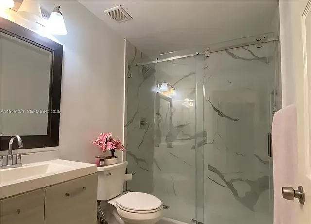 a bathroom with a sink toilet and shower