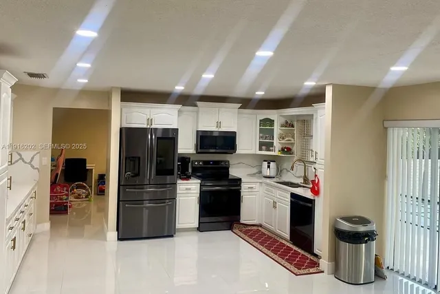 a kitchen with stainless steel appliances granite countertop a refrigerator and a stove top oven