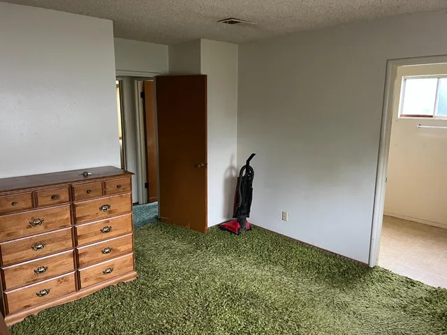 an empty room with cabinet and mirror