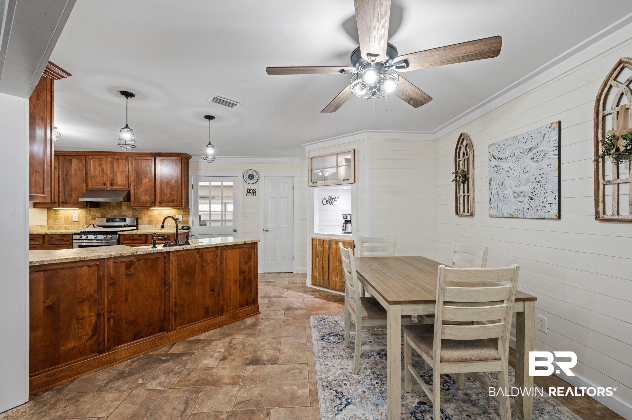 20037 County Road 33 Fairhope, AL 36532 - Photo 13 of 79 Kitchen featuring kitchen peninsula, backsplash, stainless steel gas range, decorative light fixtures, and light stone counters