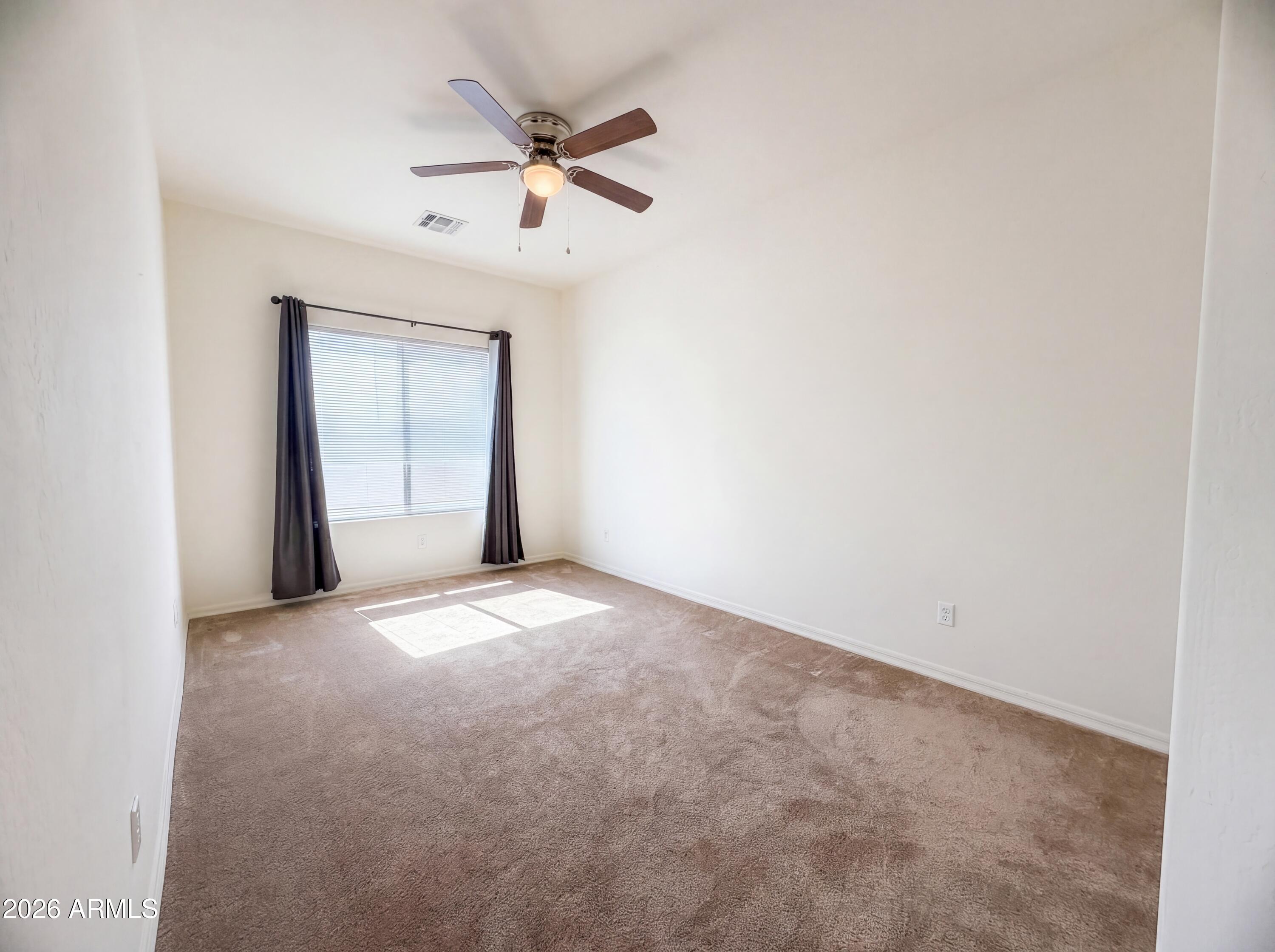 1738 South Aryelle Road Apache Junction, AZ 85119 - Photo 11 of 17 an empty room with a ceiling fan and window