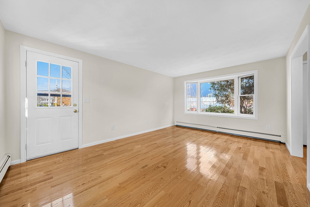 2 Cocci Way, Unit 2 Dedham, MA 02026 - Photo 11 of 30 a view of an empty room with a window and wooden floor