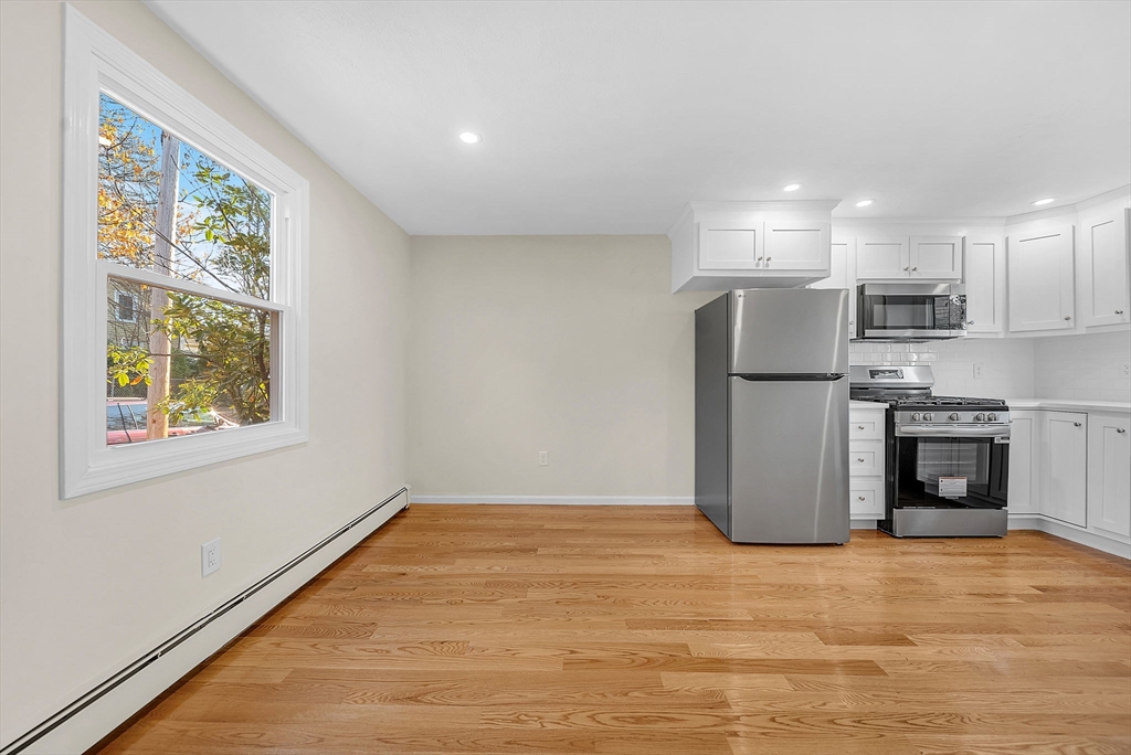 2 Cocci Way, Unit 2 Dedham, MA 02026 - Photo 14 of 30 a view of a kitchen with a refrigerator a stove top oven a ceiling fan and wooden floor