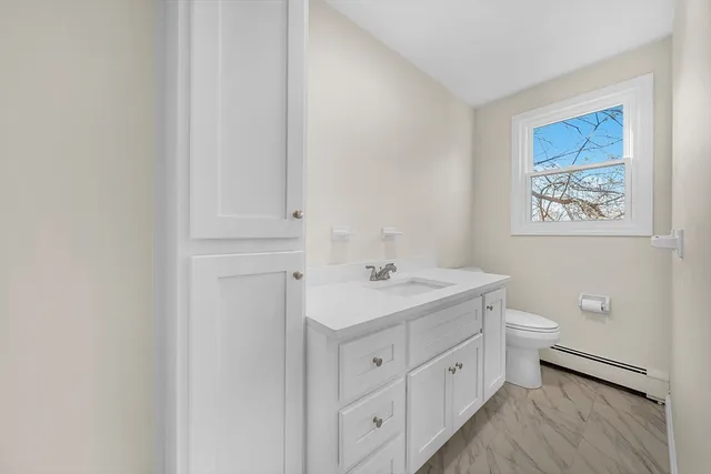 a spacious bathroom with a toilet sink and mirror