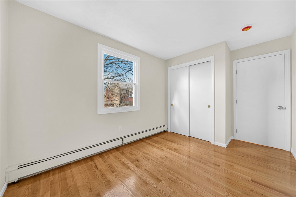 2 Cocci Way, Unit 2 Dedham, MA 02026 - Photo 22 of 30 a view of an empty room with wooden floor and a window