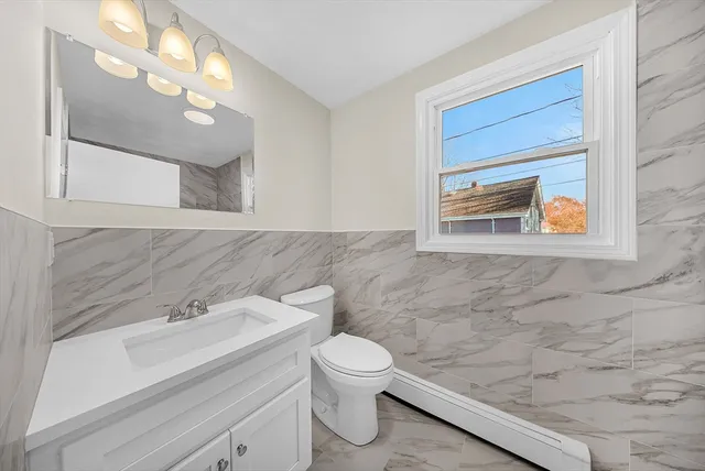 a bathroom with a toilet a sink and mirror