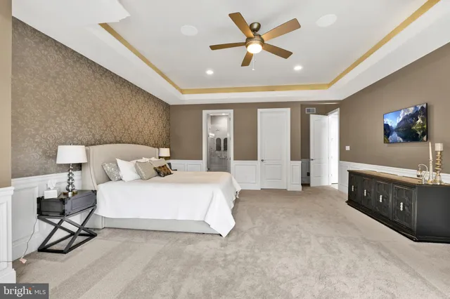 a spacious bedroom with a bed and a chandelier