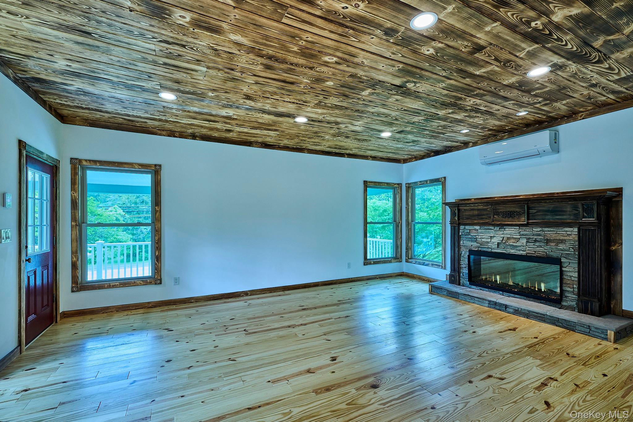 608 High Road Glen Spey, NY 12737 - Photo 21 of 37 an empty room with wooden floor fireplace and windows