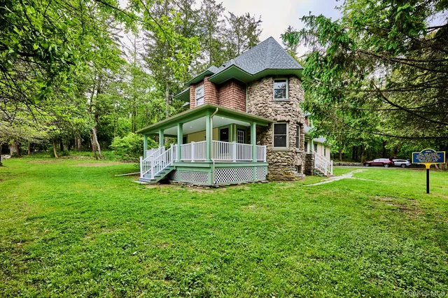 a front view of a house with a yard and trees