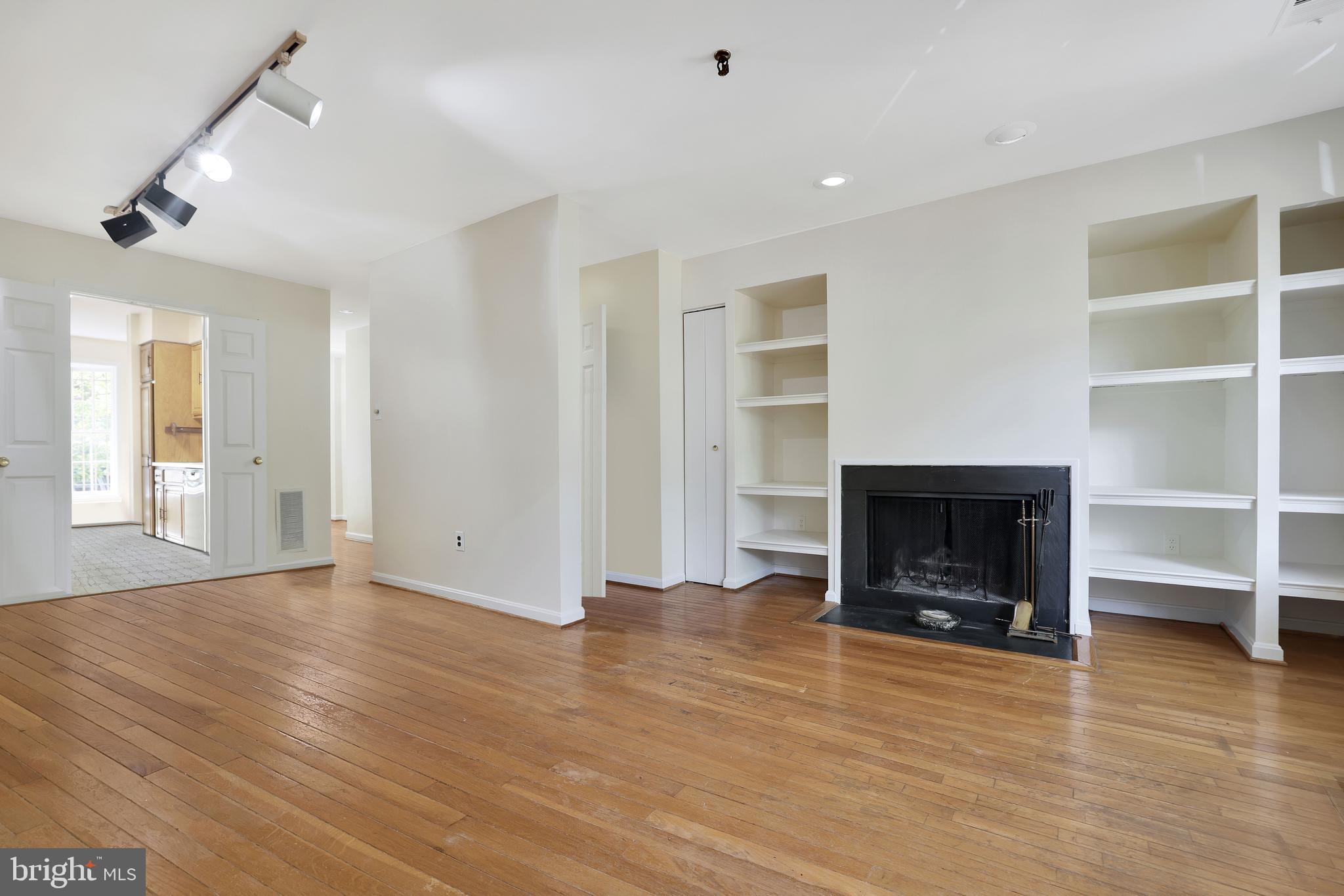 1649 Park Road Northwest Washington, DC 20010 - Photo 3 of 33 an empty room with wooden floor fireplace and windows