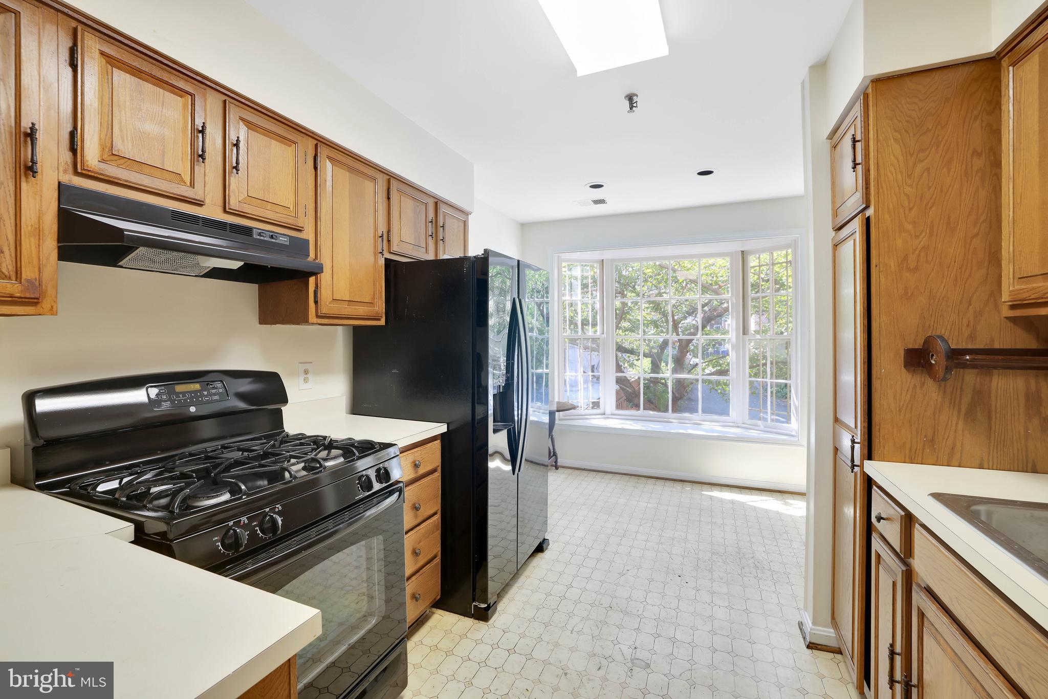 1649 Park Road Northwest Washington, DC 20010 - Photo 8 of 33 a kitchen with a stove a refrigerator and a cabinets