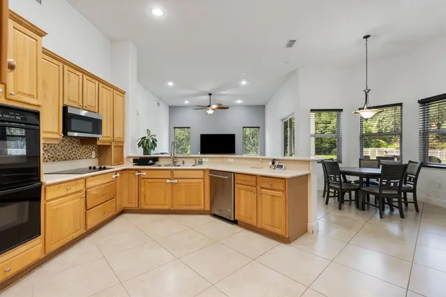 a large kitchen with kitchen island a sink a counter top space appliances and cabinets
