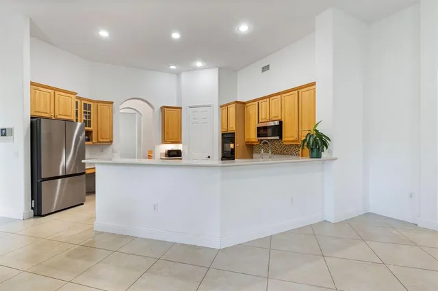 a view of kitchen with stainless steel appliances granite countertop a refrigerator and a sink