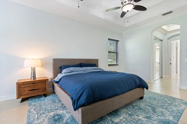 a bedroom with a bed chandelier and dresser