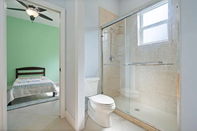 a bathroom with a granite countertop shower a toilet and a sink