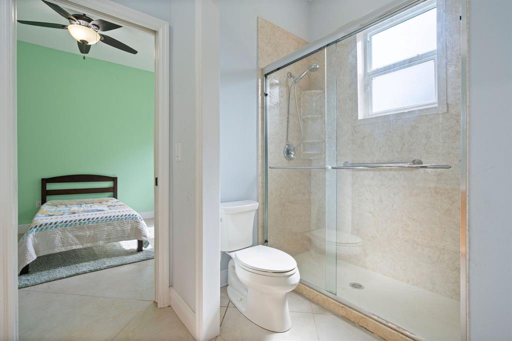 15651 Southwest 15th Street Davie, FL 33326 - Photo 37 of 47 a bathroom with a granite countertop shower a toilet and a sink