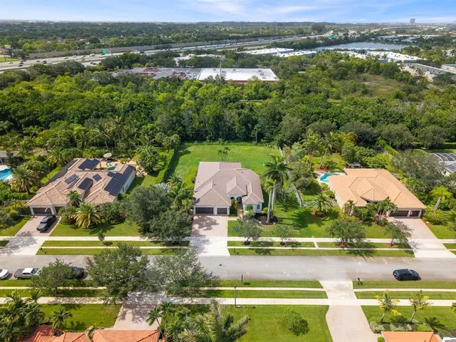 an aerial view of residential houses with outdoor space and lake view