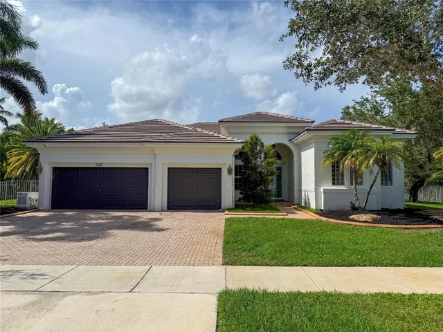 a front view of a house with a garden and yard