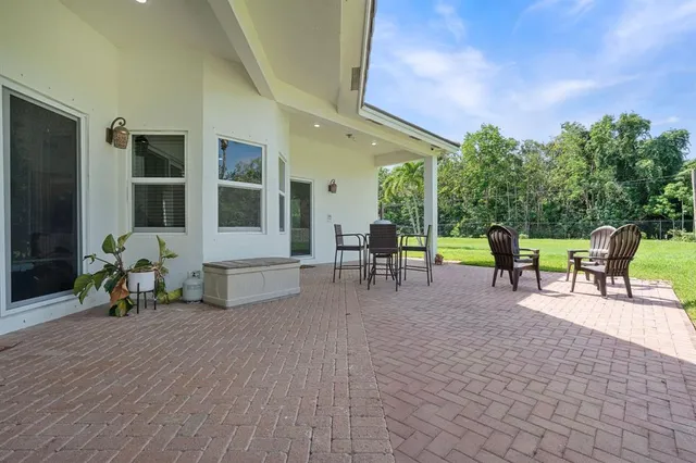 a view of a patio with table and chairs and potted plants with wooden floor and fence